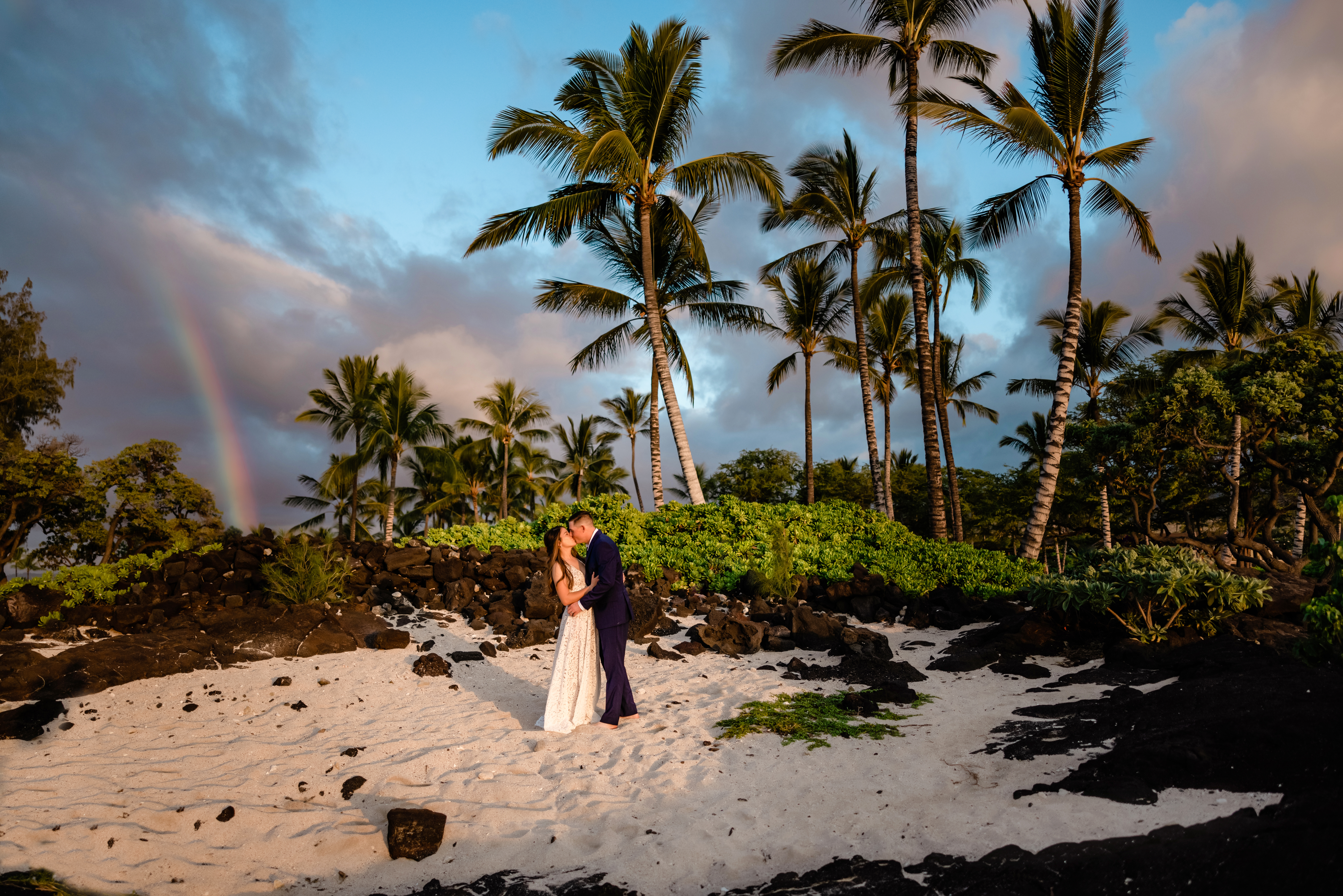 Couple on the beach with a rainbow after their Big Island elopement